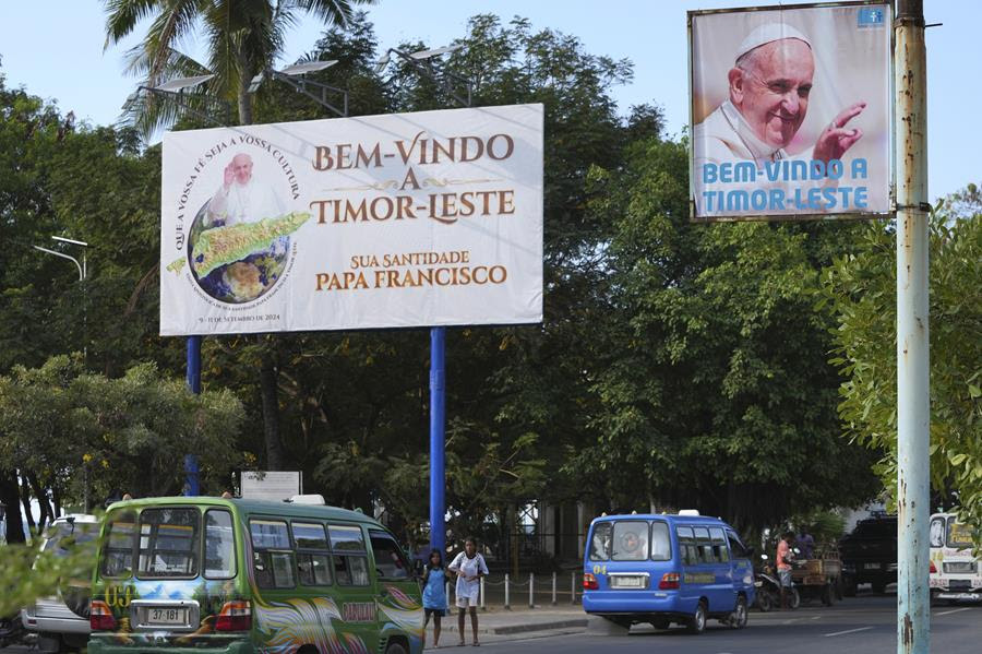 A street in East Timor with signs hanging nearby advertising Pope Francis' visit.