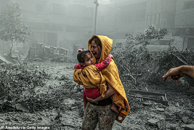 A woman holding a girl after Israeli airstrikes hit the Ridwan neighbourhood of Gaza City on October 23, 2023