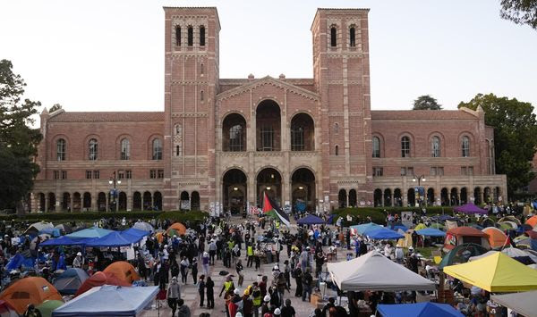 Demonstrators walk in an encampment on the UCLA campus after clashes between pro-Israel and pro-Palestinian groups, May 1, 2024, in Los Angeles. (AP Photo/Jae C. Hong, File)