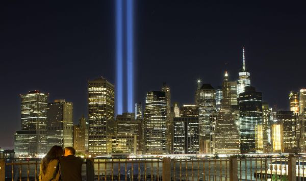 A couple embraces on the Brooklyn Promenade as the Tribute in Light rises above the lower Manhattan skyline Sunday, Sept. 10, 2017, in New York. The two blue pillars of light provide a visual reminder of how the Twin Towers, destroyed in the terrorist attacks of Sept. 11, 2001, once stood above the city skyline. (AP Photo/Mark Lennihan)