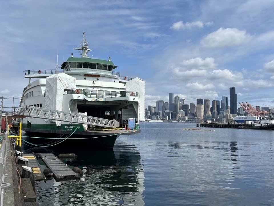 Ferry Wenatchee docked at shipyard with Seattle skyline in the background