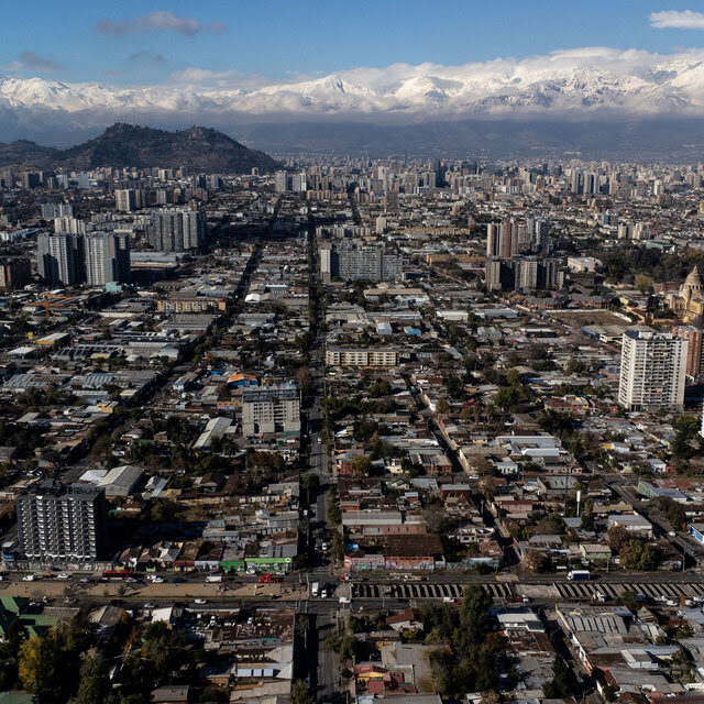 An aerial view of a large city with mountains in the background.