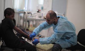 Un miembro del personal de UNRWA en Gaza proporciona atención médica a un niño.