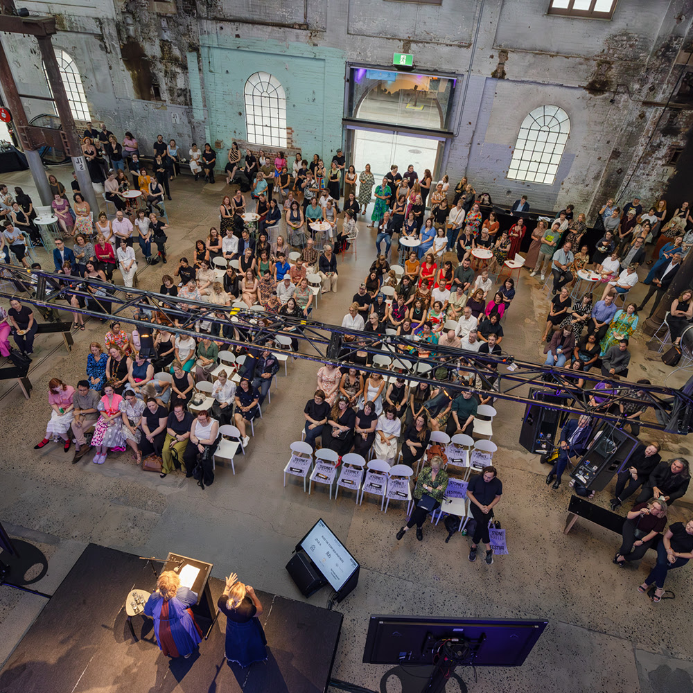 A view from above of a large, seated crowd in Carriageworks' foyer 
