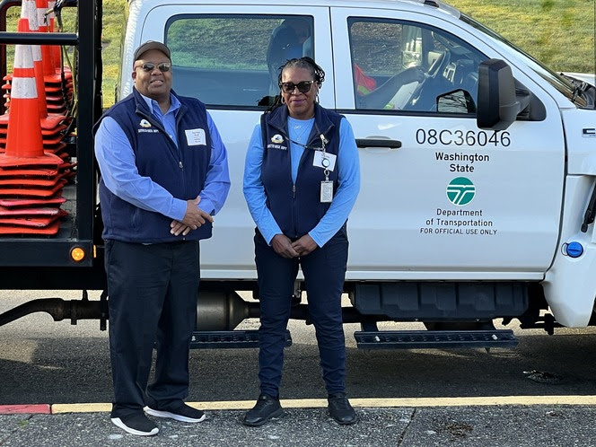 Two ferry crewmembers standing in front of a WSDOT work truck