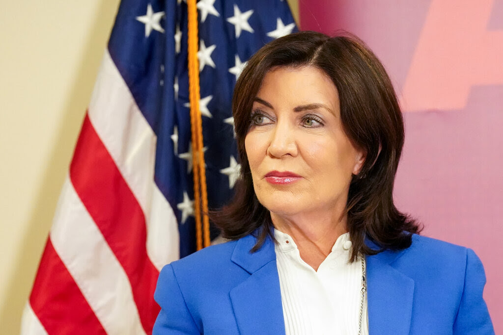 Gov. Kathy Hochul stands in front of an American flag.