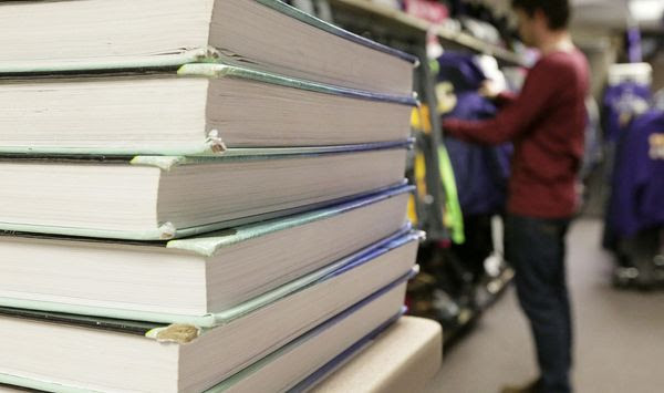 In this Feb. 18, 2016 photo, textbooks are seen stacked on a table at Illinois Valley Community College in Oglesby, Ill. In 2007, the school began the Textbook Rental Option Program to alleviate some of the burden of high textbook prices. (Scott Anderson/NewsTribune via AP) MANDATORY CREDIT