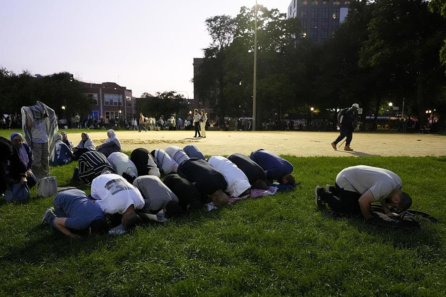 An open field where Pro-Palestinian demonstrators bow in prayer.