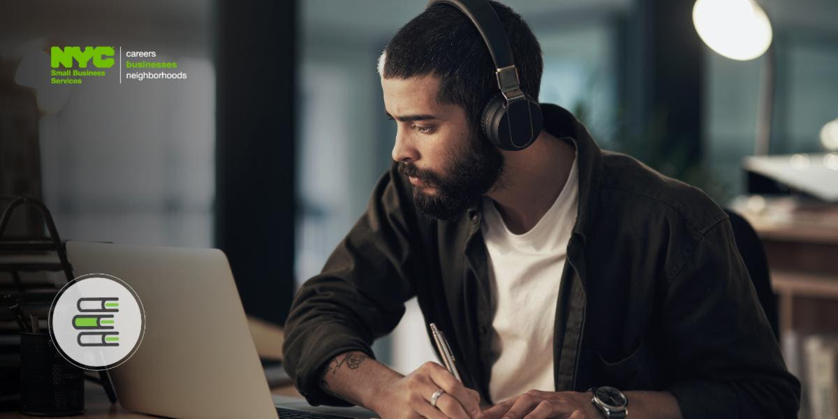 Man writes in front of laptop