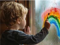 a child is painting a rainbow on a window