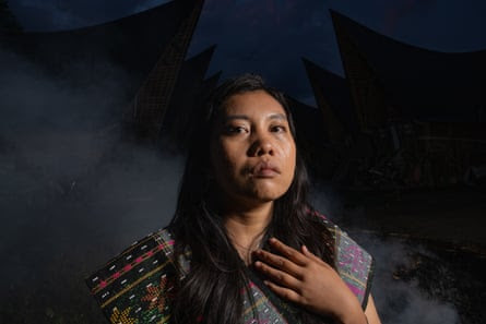 An Indigenous woman holds her hand to her chest