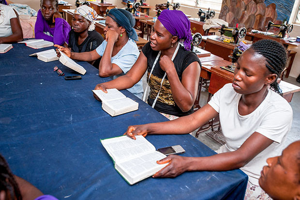 People sitting at a table reading the Bible