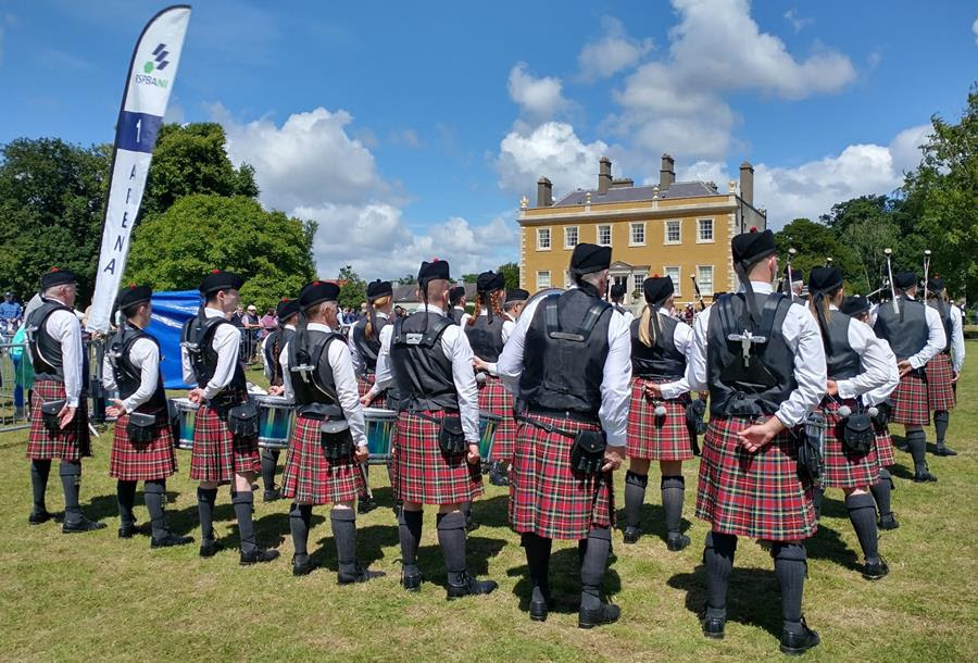 Picture of a Pipe Band in Newbridge house in the background