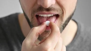 Young Man Taking Pill