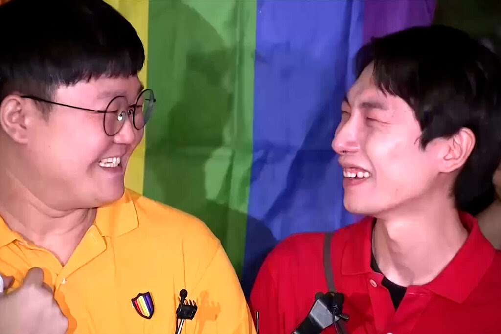 Two men smiling at each other. 