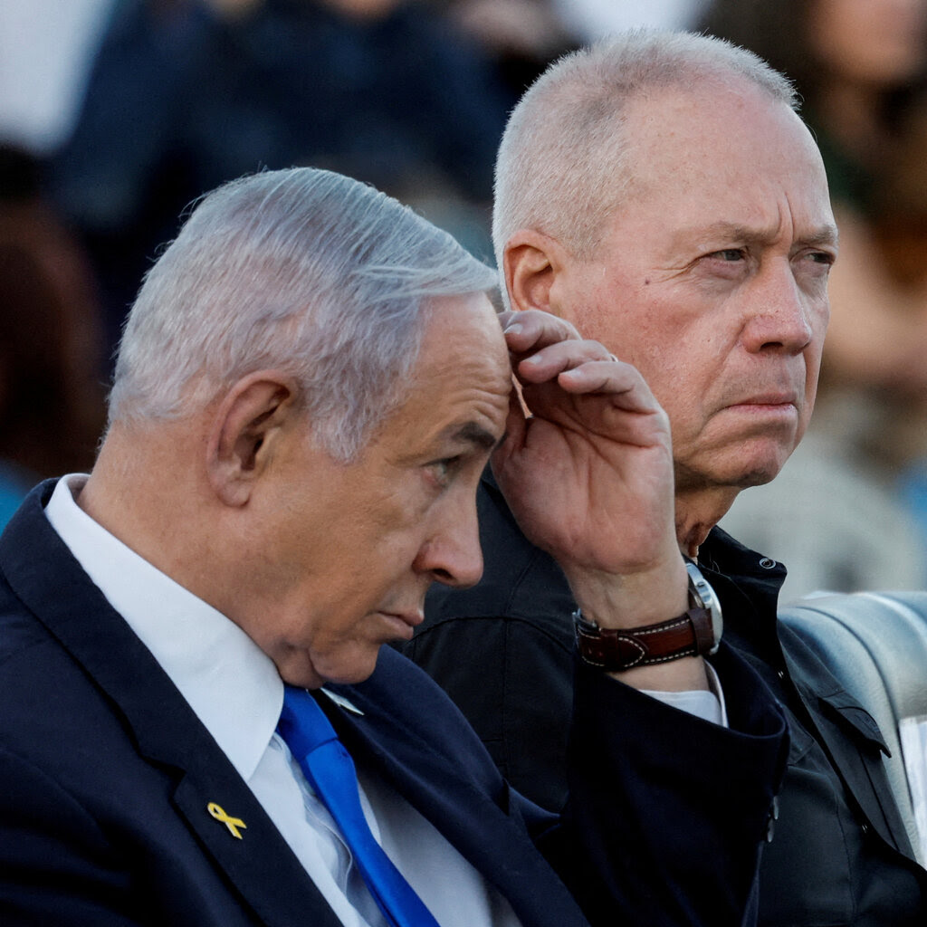 Prime Minister Benjamin Netanyahu rubs at his forehead. Next to him is Yoav Gallant, the former defense secretary of Israel.