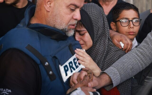 Al Jazeera's bureau chief in Gaza, Wael Al-Dahdouh, hugs his daughter and holds his son's hand during the funeral of his son Hamza Wael Dahdouh, a journalist with Al Jazeera who was killed in an Israeli air strike in Rafah in the Gaza Strip on January 7, 2024. The IDF said Hamza Wael Dahdouh and a freelance journalist, Mustafa Thuria, were traveling in a vehicle with a terror operative operating a drone. (Photo by AFP)