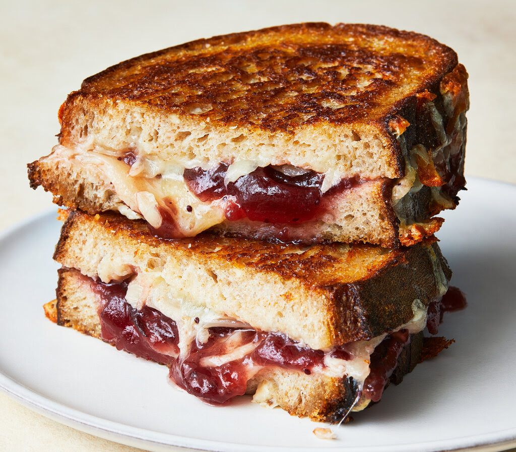 A grilled cheese sandwich oozing cranberry sauce.