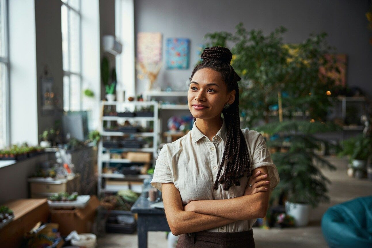 Photo of a woman with a thoughtful expression and folded arms assessing a space