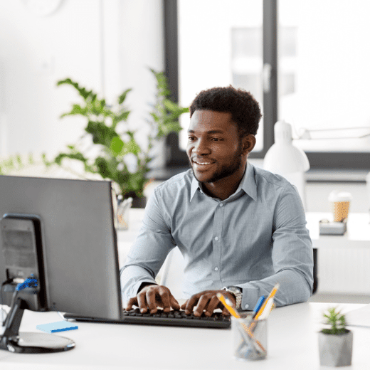 Man happily working at desk in a corporate office