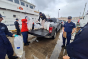 Several aw enforcement officals process evidence at a port in San Juan, Puerto Rico on a cloudy day.