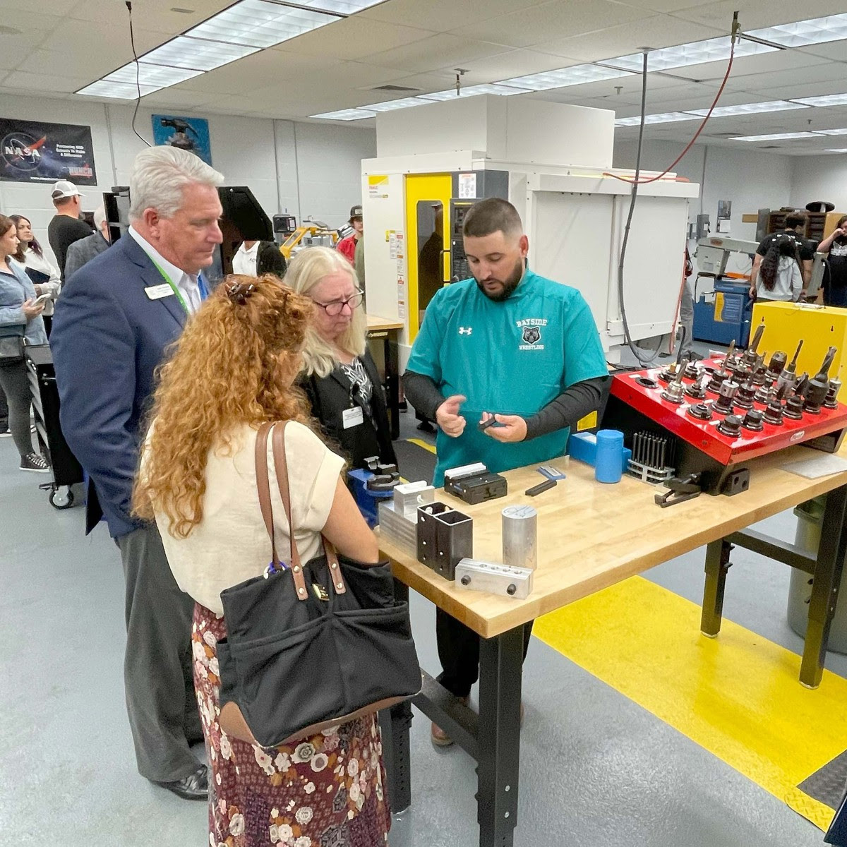 Chris Eaves shows board member John Thomas, and BPS employees Sue Hann and Farrah Sharkoorian aspects of the machining workshop