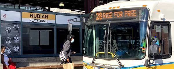 the 28 bus waits for passengers at nubian
square platform e. the bus's banner reads: 28 ride for free