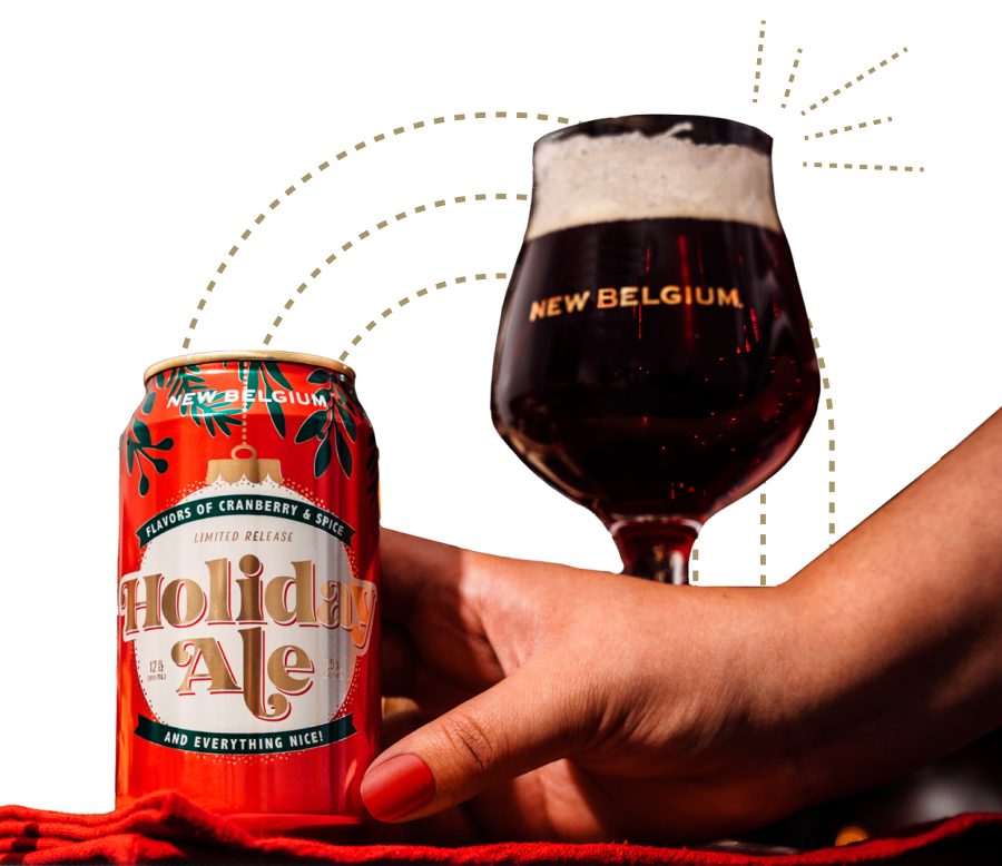 A hand holding a glass of beer labeled "New Belgium" with flavors of cranberry and spicy, indicating it's a limited release holiday ale.