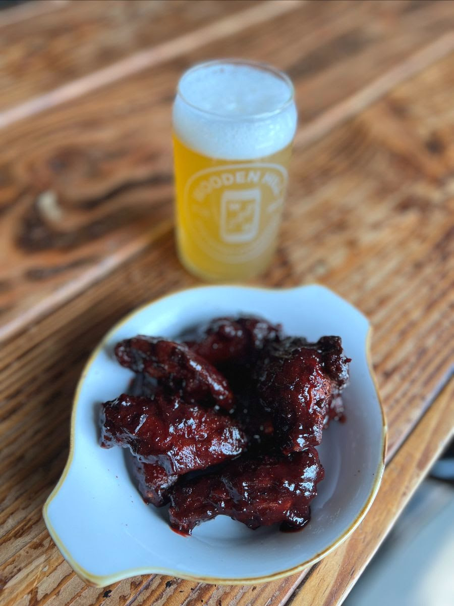 Picture of new Blueberry Bourbon BBQ Wings. Picture includes light beer in background.
