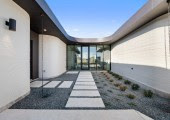 La vivienda se organiza con dos alas que se ramifican desde un gran salón central, albergando dormitorios y espacios comunes respectivamente.