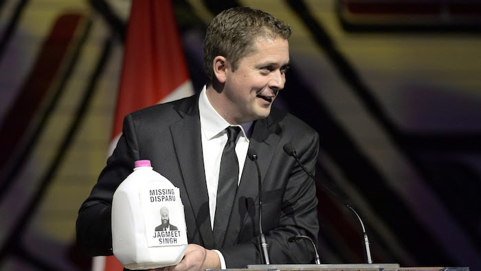 Andrew Scheer holds a milk can at a Canadian Press Gallery dinner.