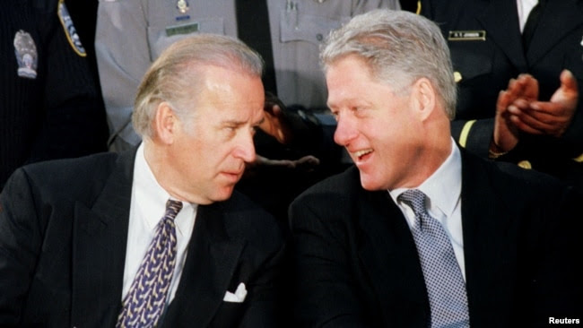 FILE - U.S. President Bill Clinton talks with Senator Joseph Biden at a meeting with law enforcement officers at the Alexandria, Virginia, Jan. 14, 1999.