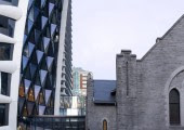 El rascacielos se construyó junto a una iglesia de principios del siglo XX que la integra en la base del edificio.