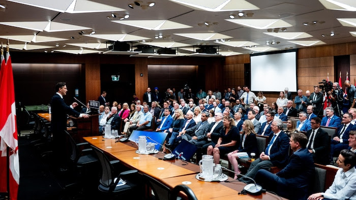 Pierre Poilievre addresses Conservative elected officials in a conference room in Ottawa.