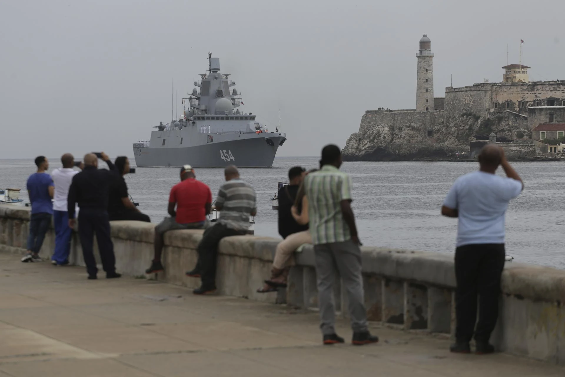 People watch the Russian Navy Admiral Gorshkov frigate arrive at the port of Havana.