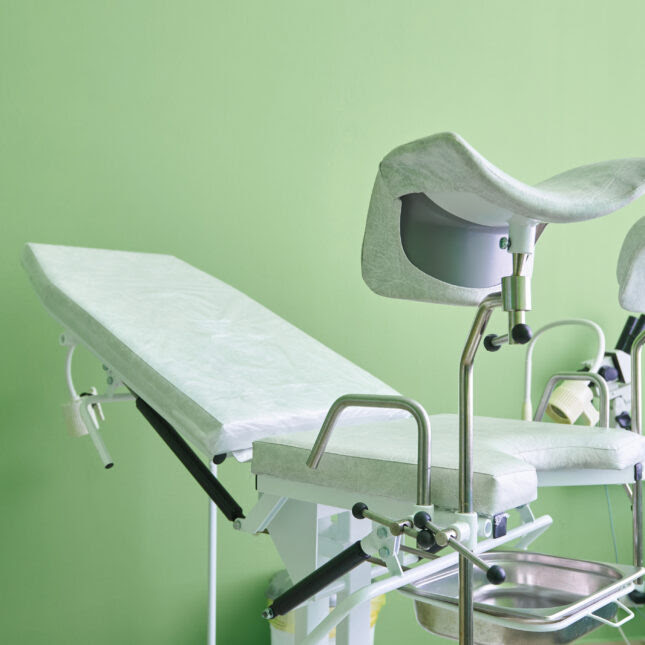 A gynecological examination chair in front of a green wall -- coverage from STAT