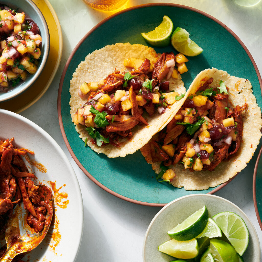 Pavo al pastor, with meat and salsa on a tortilla on a turquoise plate.