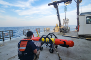 An engineer downloads images collected from a long-range autonomous underwater vehicle on deck of a research vessel