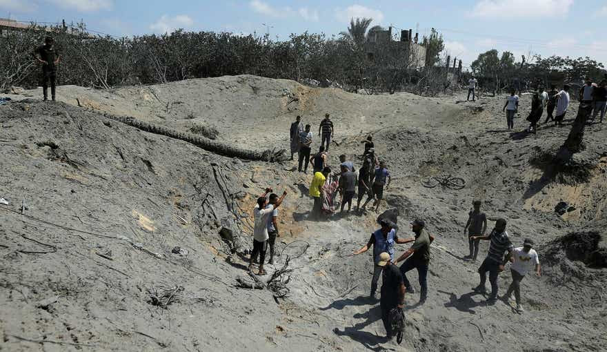 Palestinians search for bodies and survivors in a site hit by an Israeli bombardment on Khan Younis, southern Gaza Strip, Saturday, July 13, 2024. Israel said it targeted Hamas' shadowy military commander in a massive strike Saturday in the crowded southern Gaza Strip that killed at least 71 people, according to local health officials. Hamas immediately rejected the claim that Mohammed Deif was in the area. (AP Photo/Jehad Alshrafi)