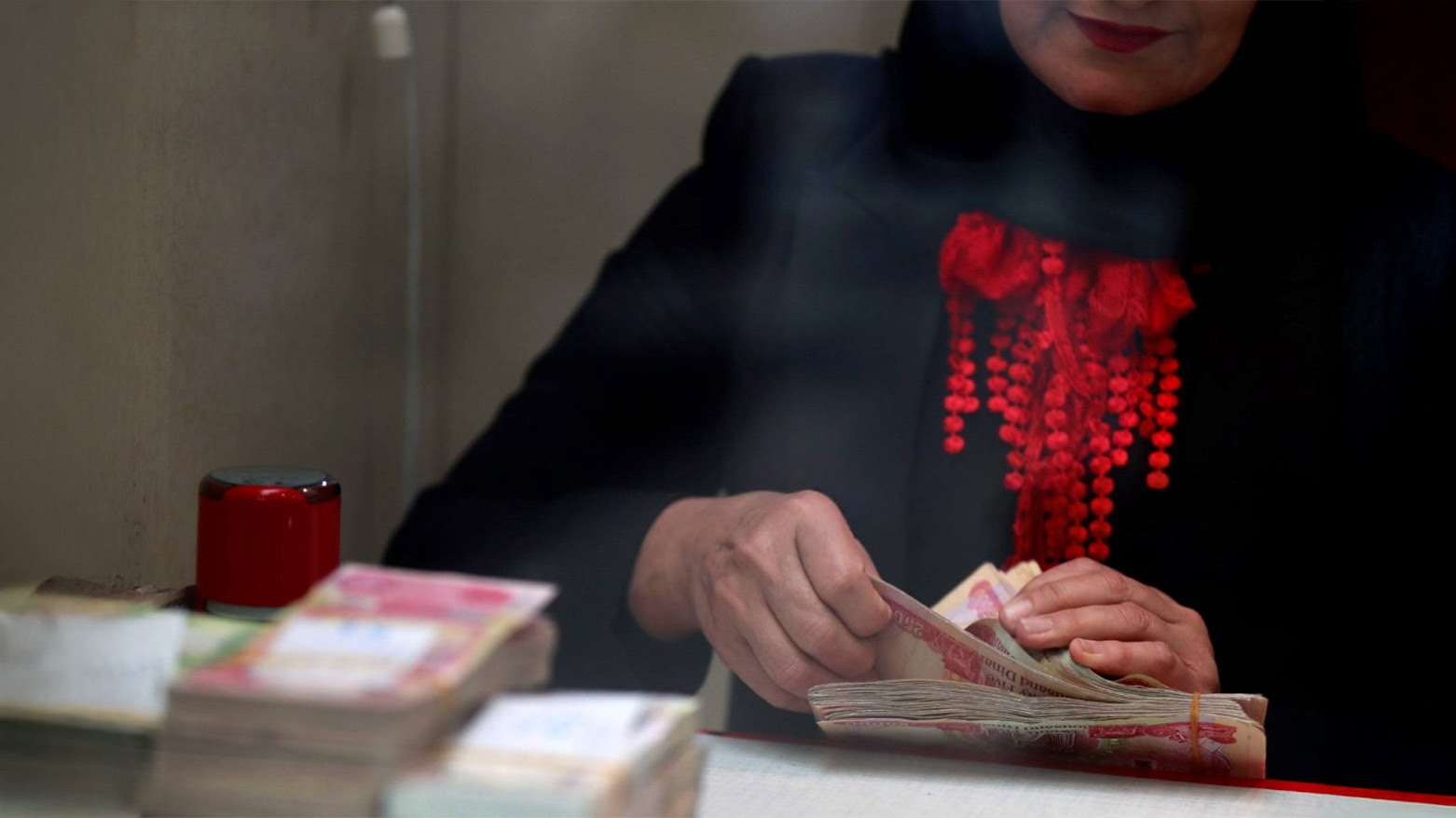 A woman counts dinars at Iraq’s Central Bank in Baghdad’s Shorja district, March 9, 2023. (Photo: AFP)