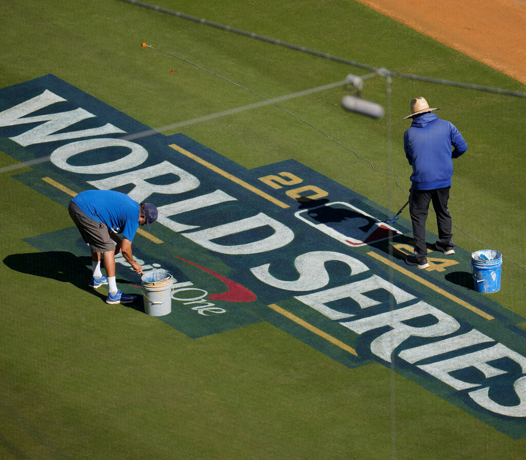 Two workers in Los Angeles prepare the field ahead of the World Series.