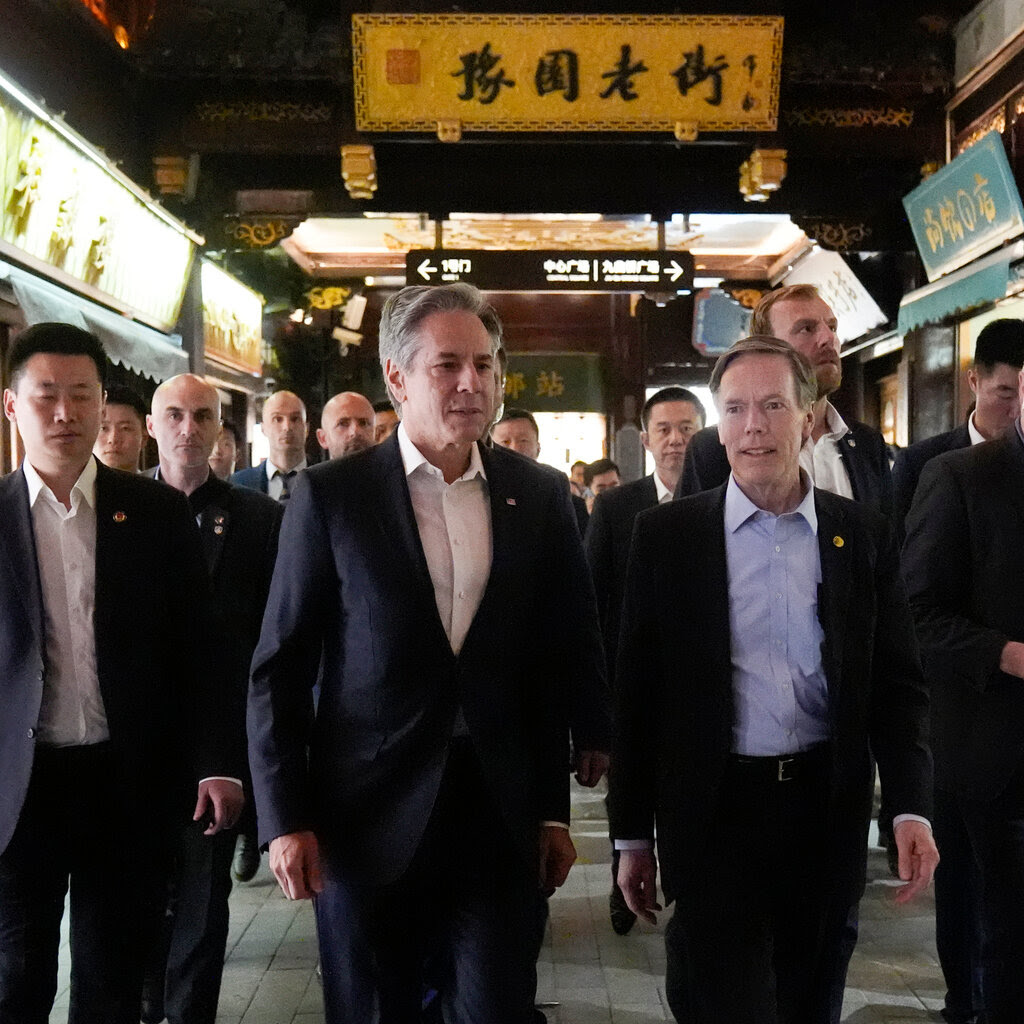 A group of men walk together. All appear to be wearing jackets; none are wearing ties. 