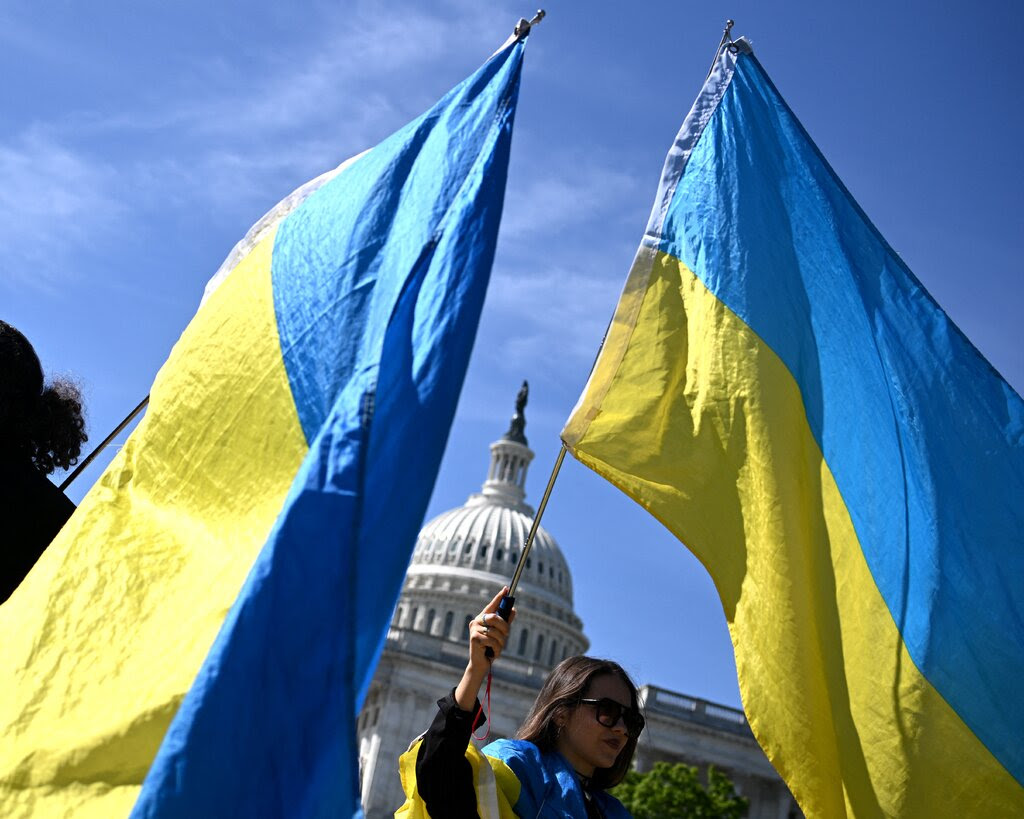 People waving Ukraine flags outside the Capitol.