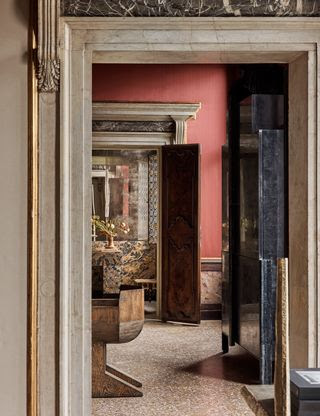 Una vista de enfilada a través del dormitorio principal muestra una silla de madera contrachapada de Rick Owens y un gabinete de plata alemana...