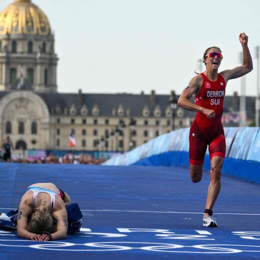 France's Cassandre Beaugrand (L) reacts after crossing first next to Switzerland's Julie Derron on the Pont Alexandre III at the end of the women's individual triathlon race at the Paris 2024 Olympic Games in central Paris, on July 31, 2024. (Photo by Jeff PACHOUD / AFP)