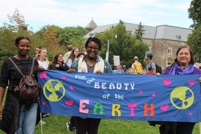 Alydia and others holding a banner that reads "For the Beauty of the Earth"