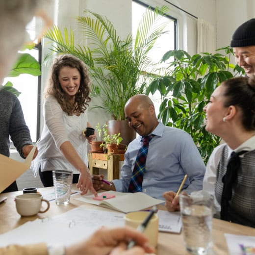 Employees happily sitting around a table