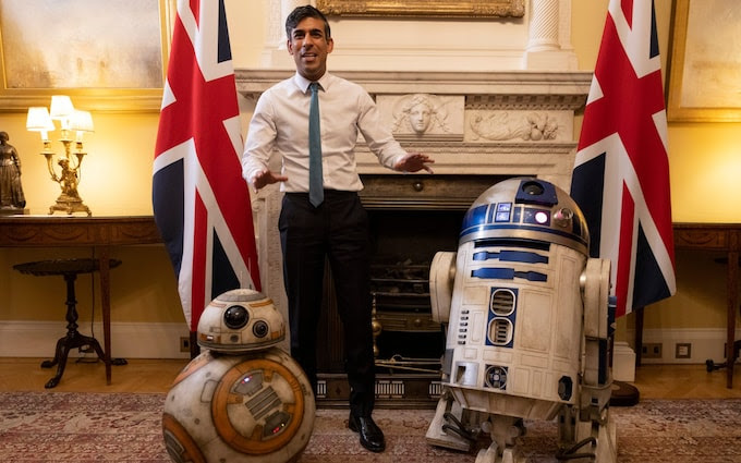 Rishi Sunak stands with R2D2 and BB-8 from Star Wars
