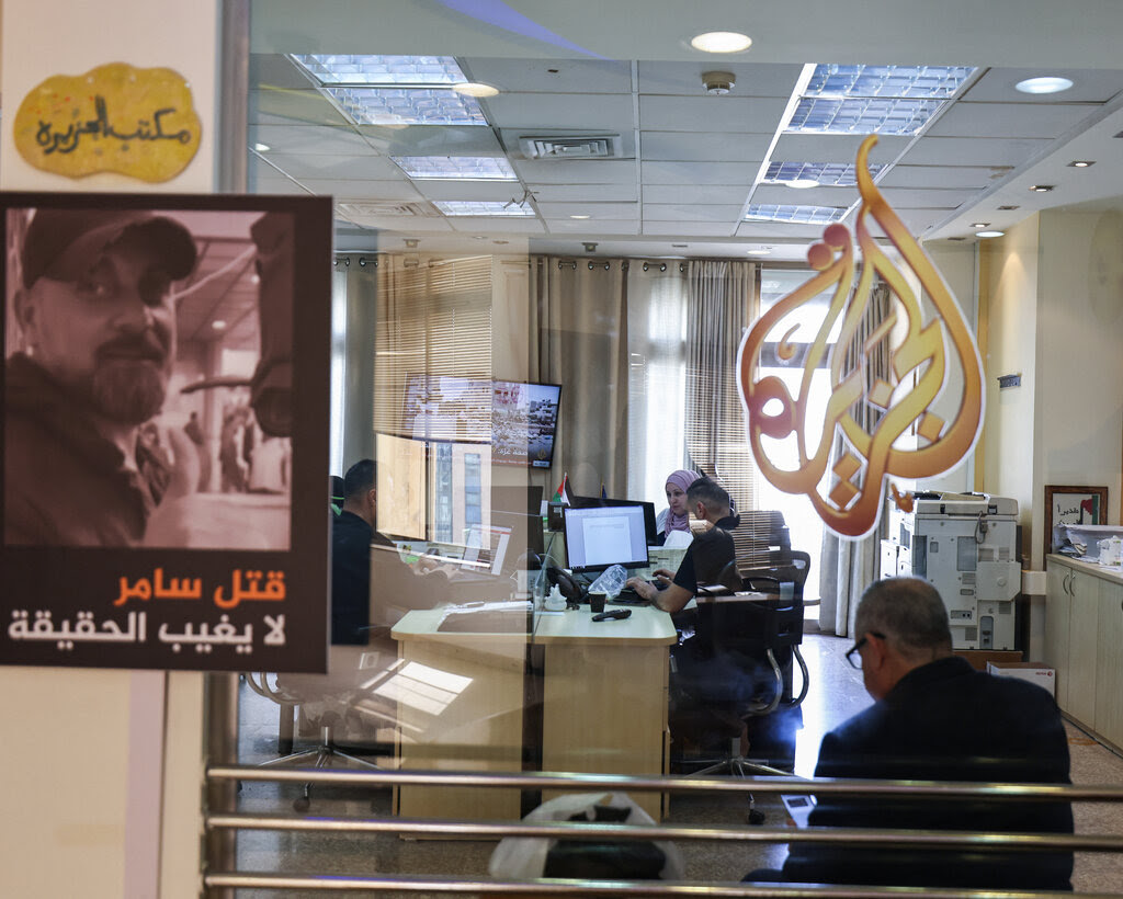 An office with Al Jazeera’s logo on the glass. 