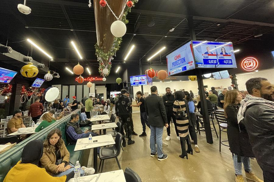 A restaurant with people gathered for an election viewing party.